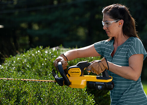 woman using hedge trimmer