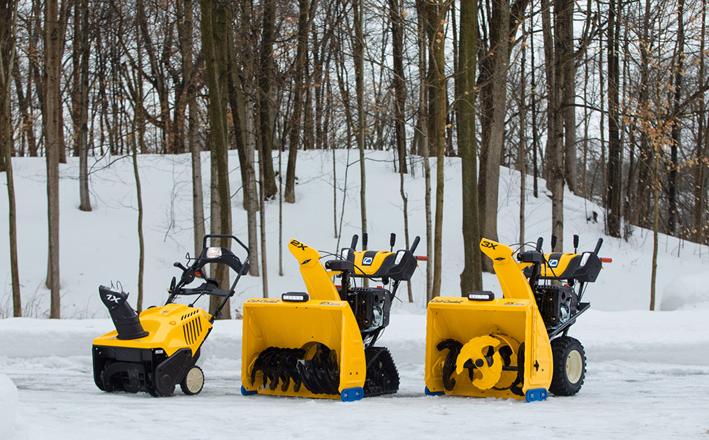 Three Cub Cadet series snow blowers lined up outside on the snow