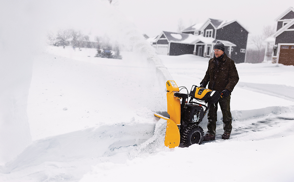 Man pushing 3 stage snow blower through heavy snow