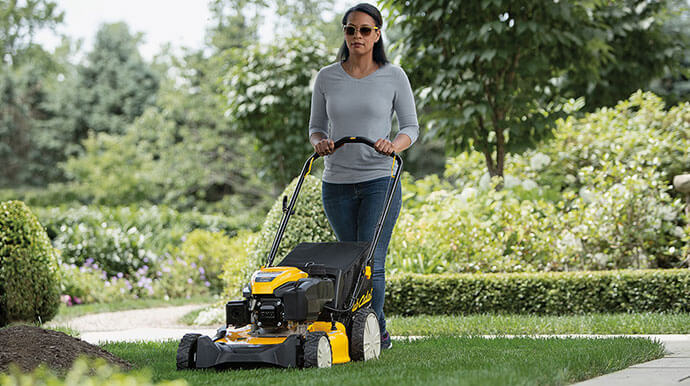woman mowing with walk behind