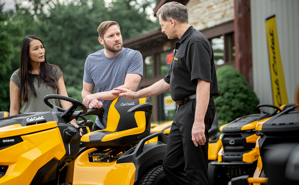 dealer with customers showing riding mowers