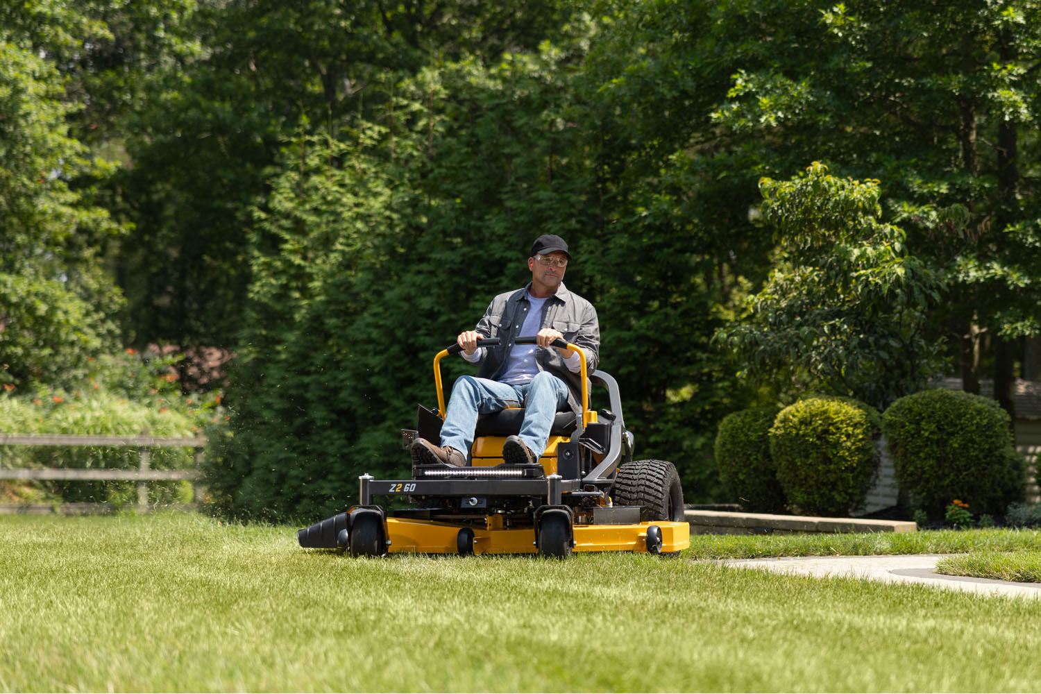man on cub cadet zero-turn mower cutting grass