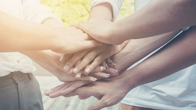 people's hands coming together