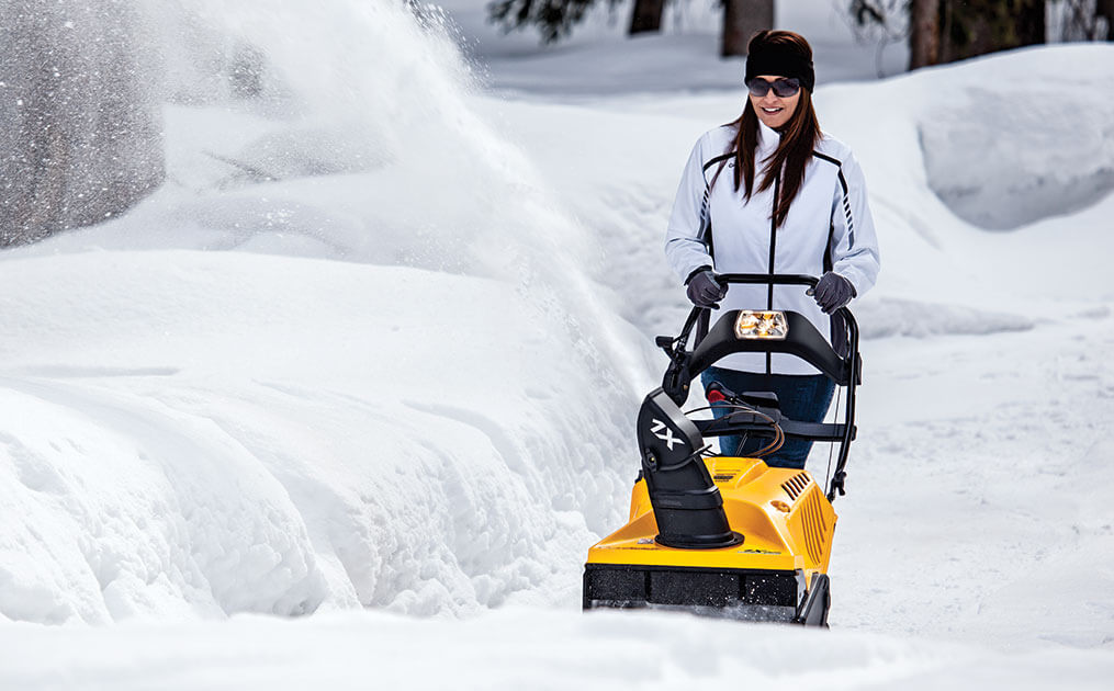 Woman snow blowing her driveway