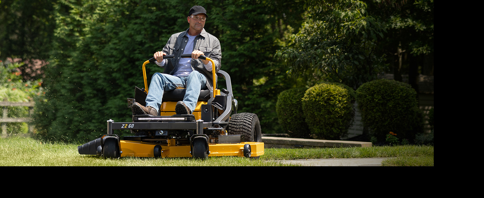man on cub cadet zero-turn mower cutting grass