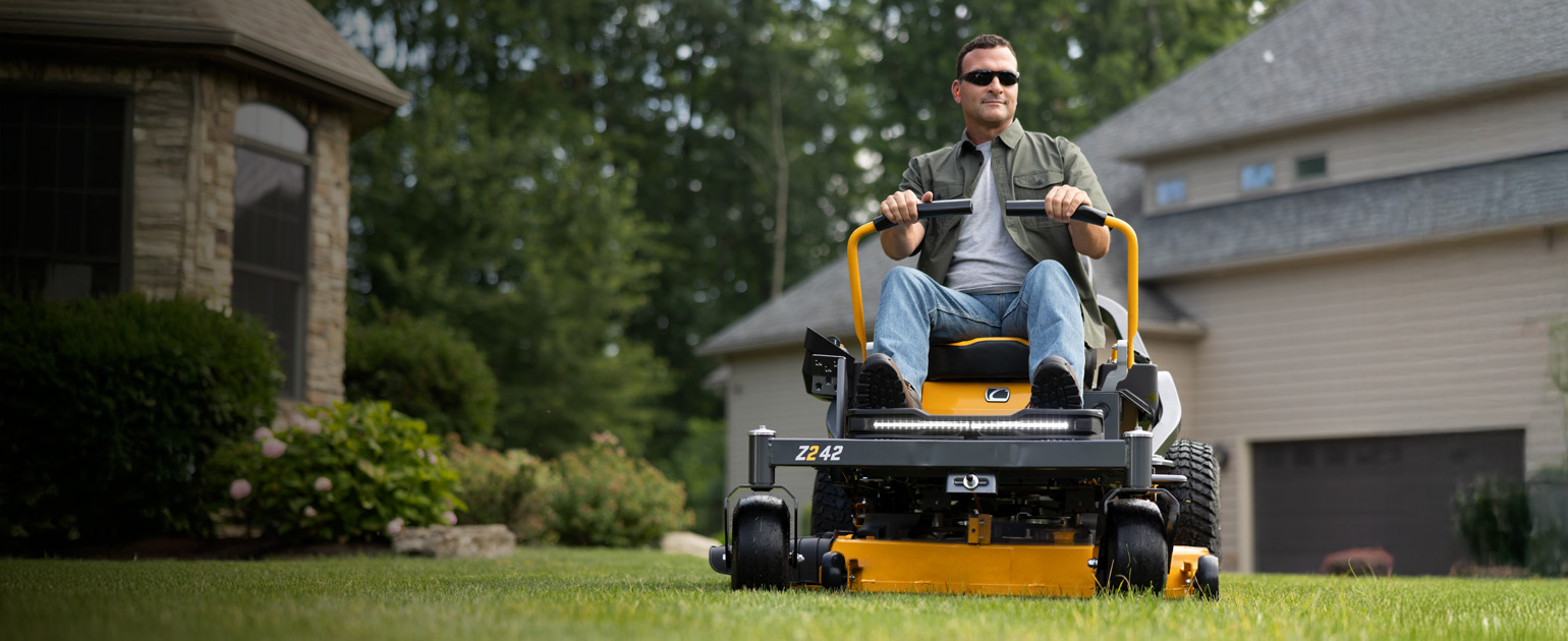 man on cub cadet zero-turn mower cutting grass