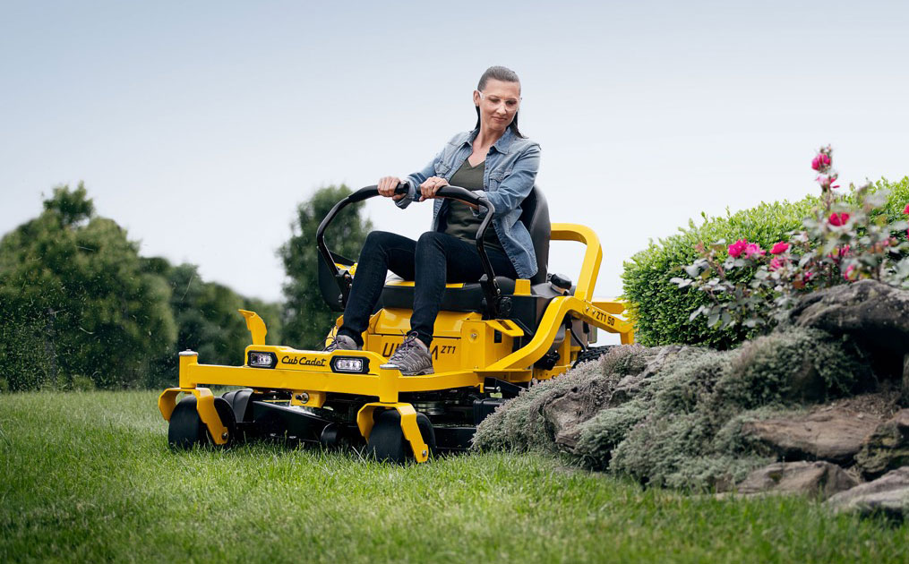 woman cutter her lawn with a zero-turn mower