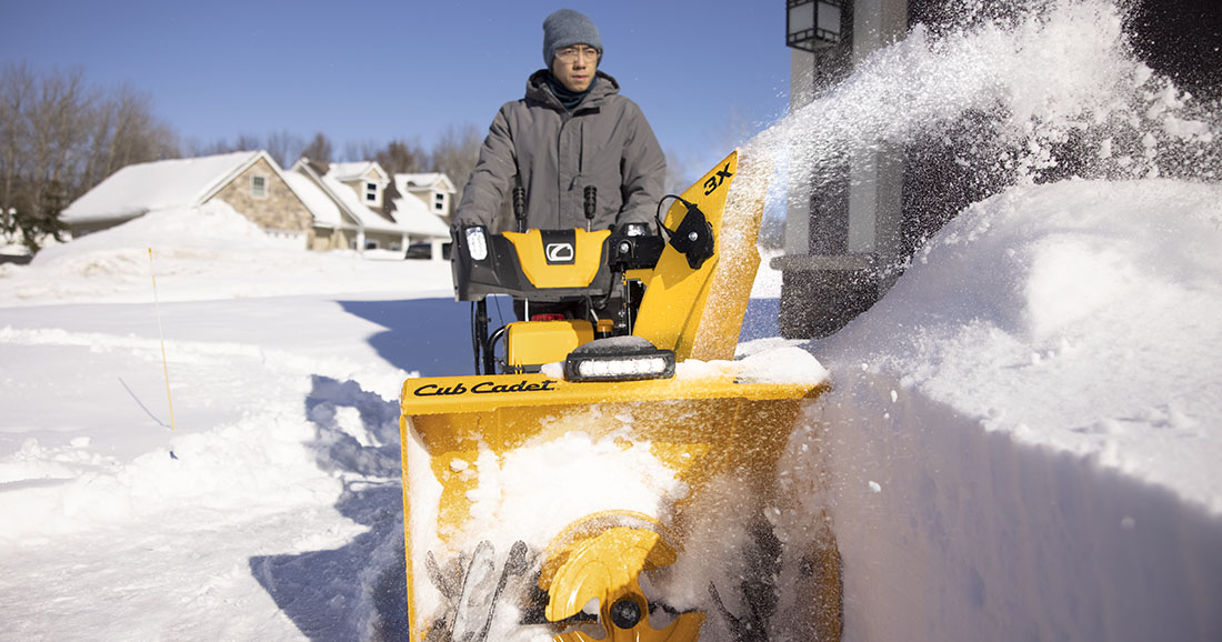 Man pushing Cub Cadet 3X snow blower through snow