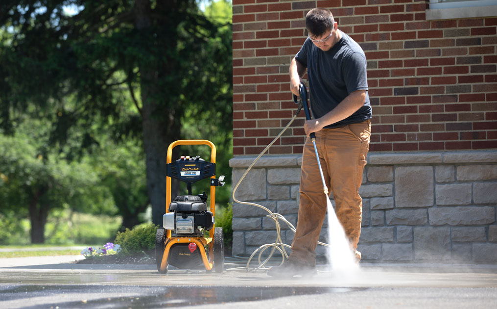 man power washing the driveway