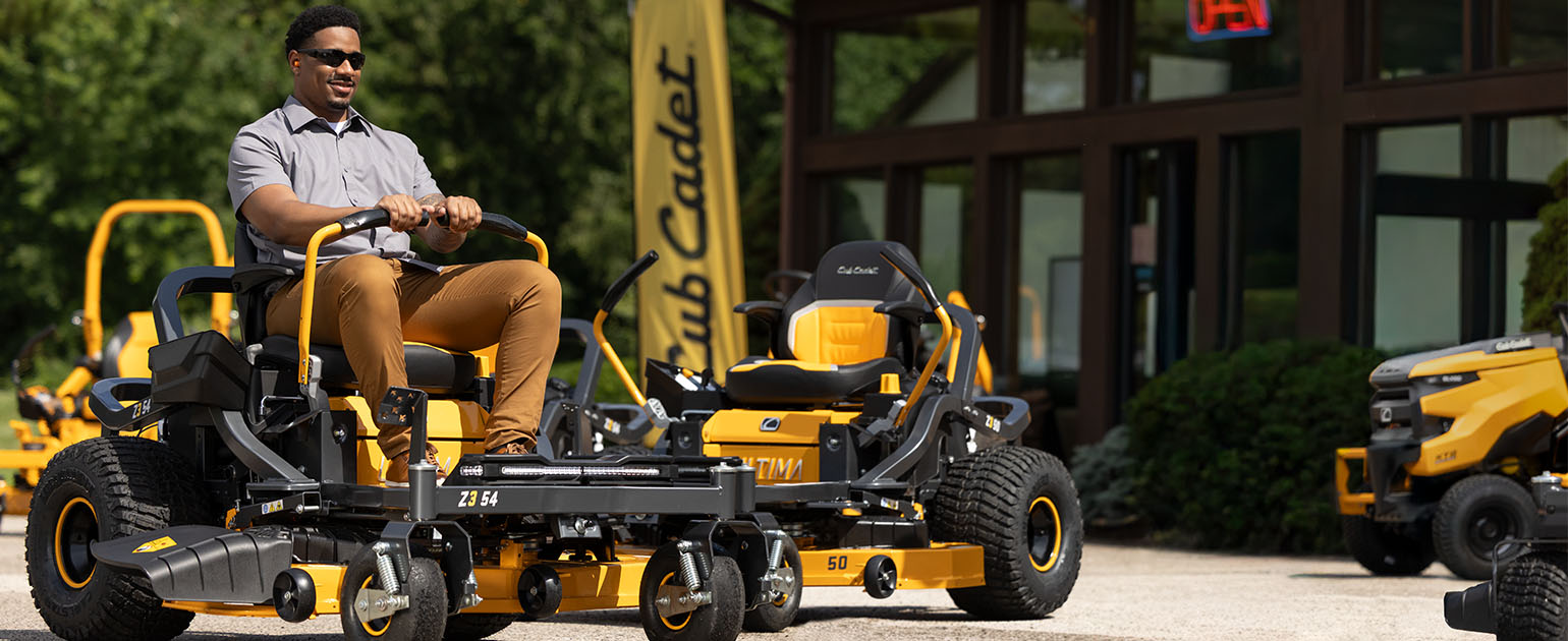 man on cub cadet zero-turn mower cutting grass