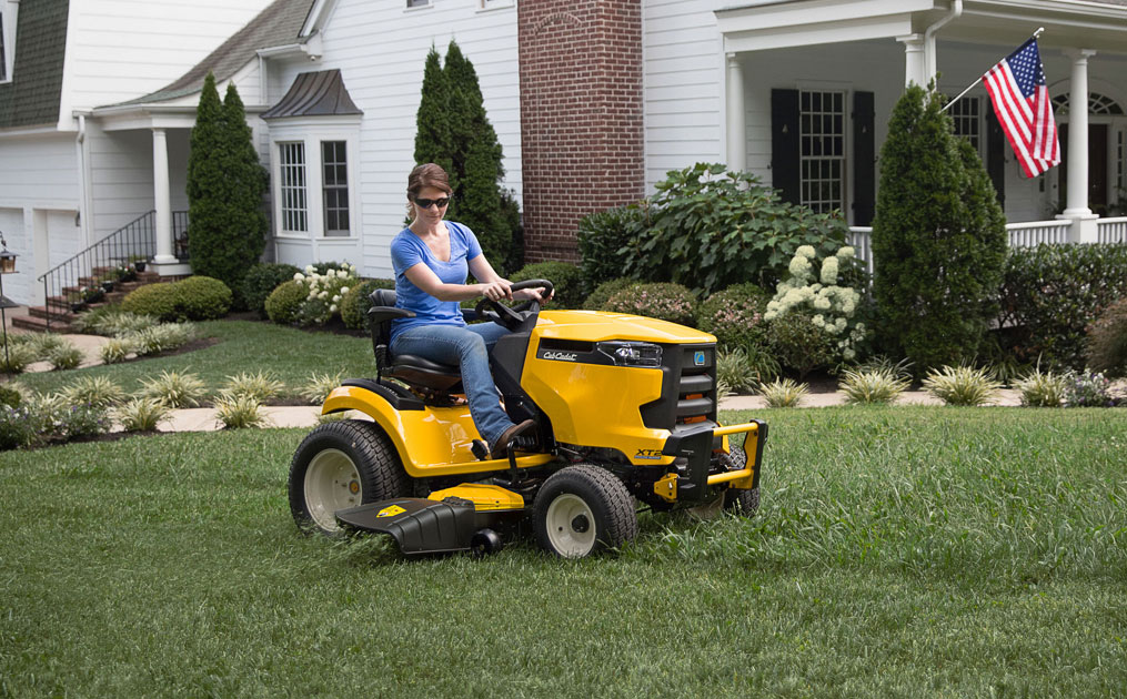 woman mowing the yard with a riding lawn mower