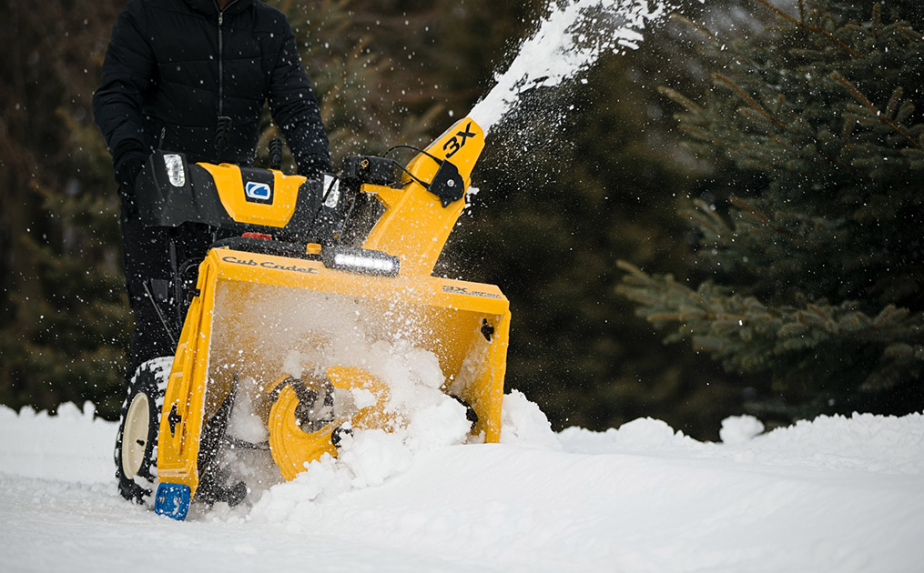 Three Cub Cadet series snow blowers lined up outside on the snow