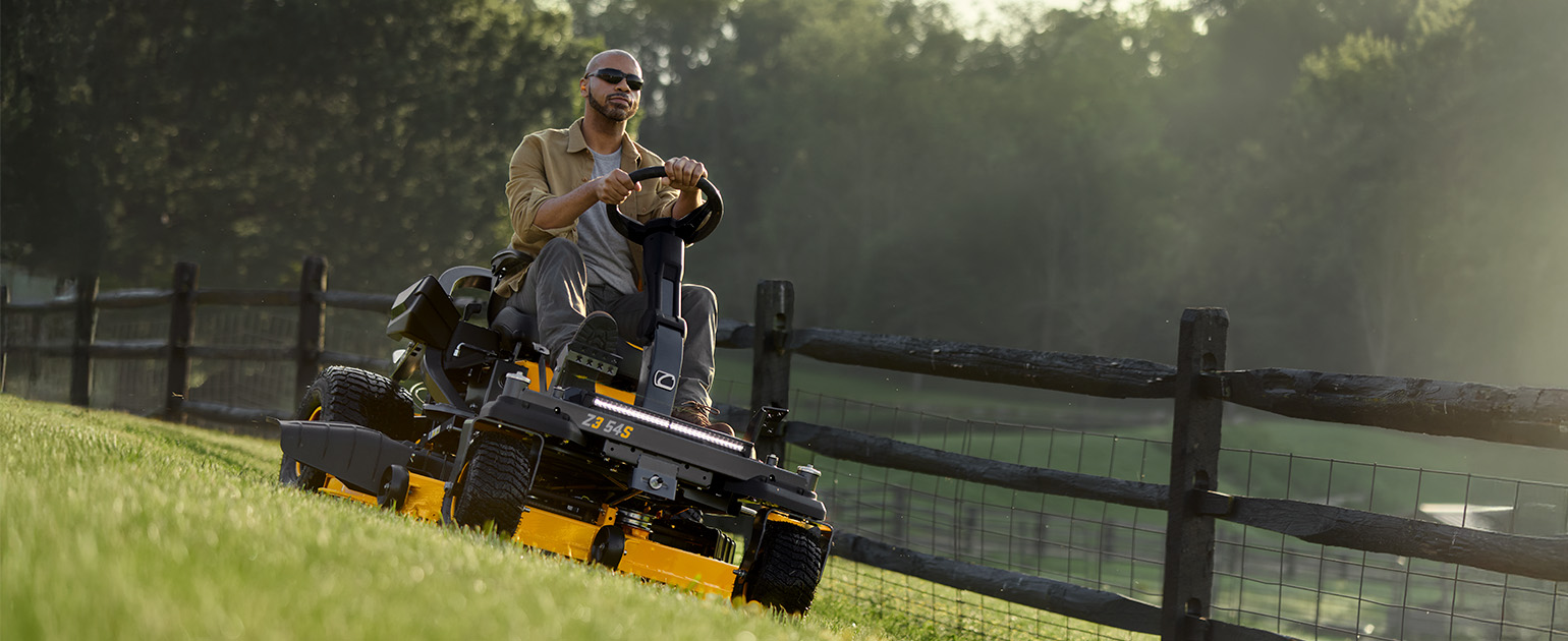 man on cub cadet zero-turn mower cutting grass