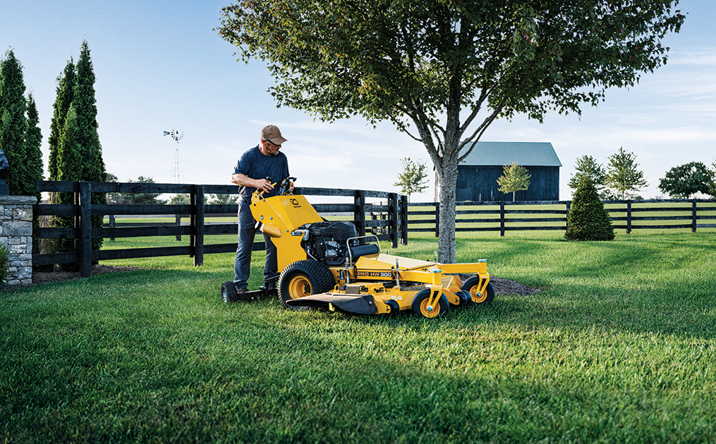man cutting grass with professional stand on mower